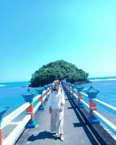 Dari atas jembatan dengan latar belakang laut lepas