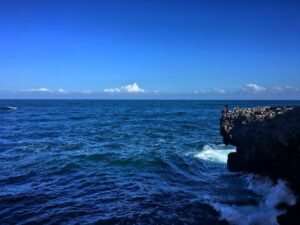 Menikmati keindahan Pantai Sugu dari atas tebing