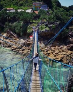 Foto di tengah jembatan dengan latar belakang bukit