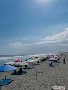 Suasana yang cukup ramai dengan payung warna-warni di tepi pantai