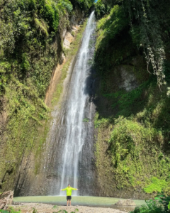 Foto dengan latar belakang air terjun yang megah